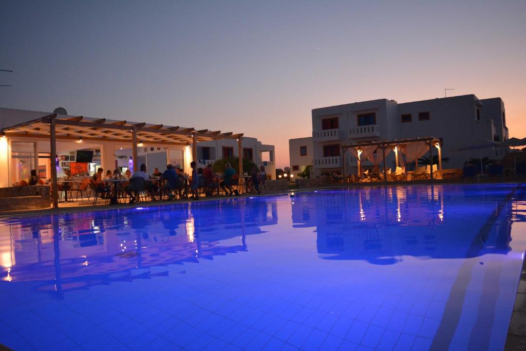 马尔马里Bouradanis Village Hotel的大楼前方的大型蓝色海水游泳池