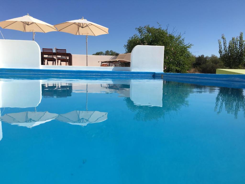 阿尔沃尔Quinta David的一个带蓝色水和遮阳伞的游泳池