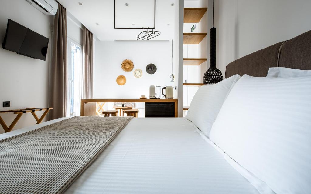 提诺斯Eleana Hotel的卧室配有白色的床和书桌