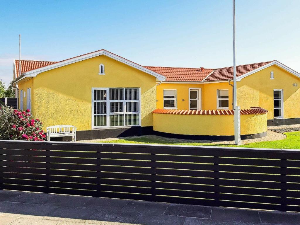 斯卡恩Holiday home Skagen XXX的前面有栅栏的黄色房子
