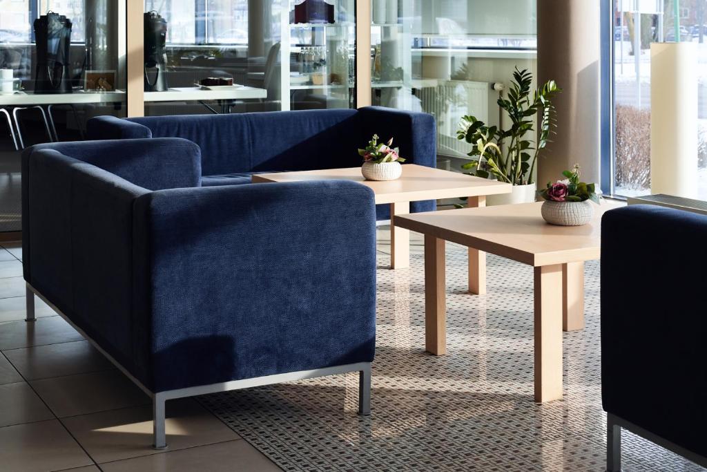 克莱佩达Green Park Hotel Klaipeda的一间设有两张蓝色椅子和一张桌子的房间