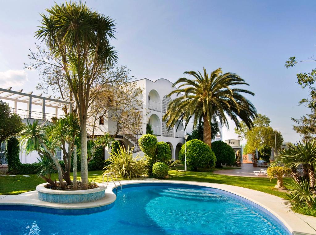 桑特佩尔佩斯卡多尔厄尔莫利酒店的棕榈树屋前的游泳池