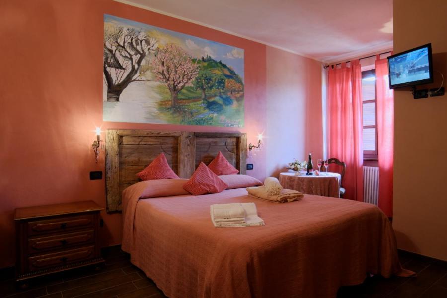 BubbioTre colline in langa的卧室配有一张大床,墙上挂有绘画作品