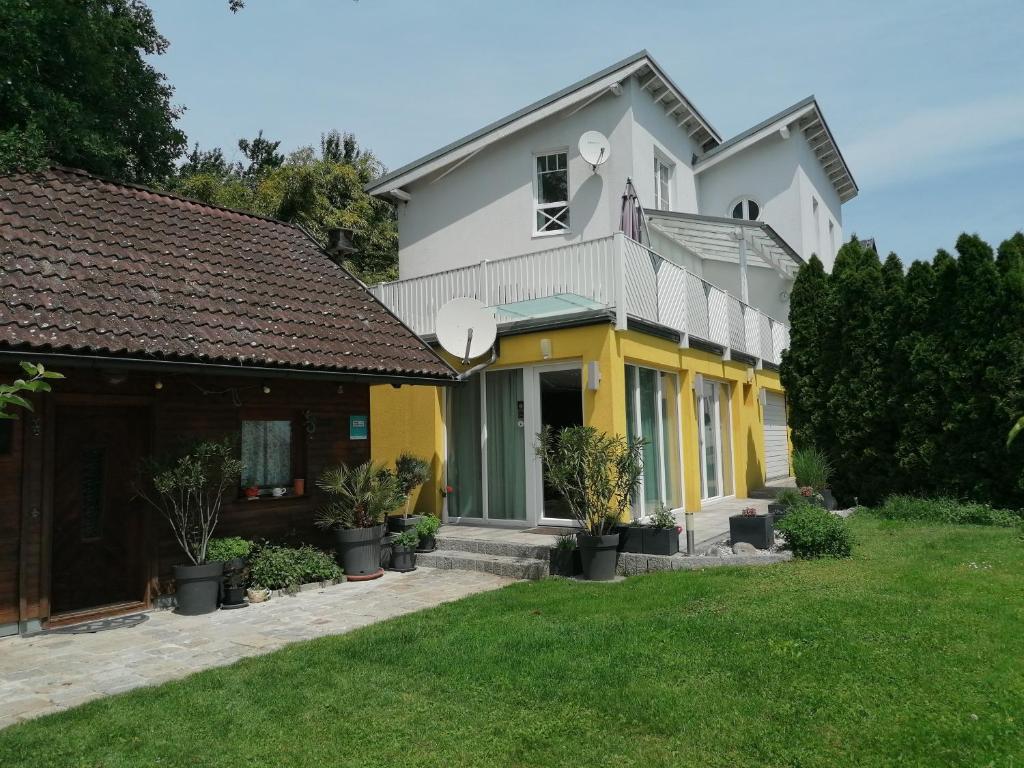 多瑙河畔伊布斯伊布斯花园公寓的白色和黄色的房子,有院子