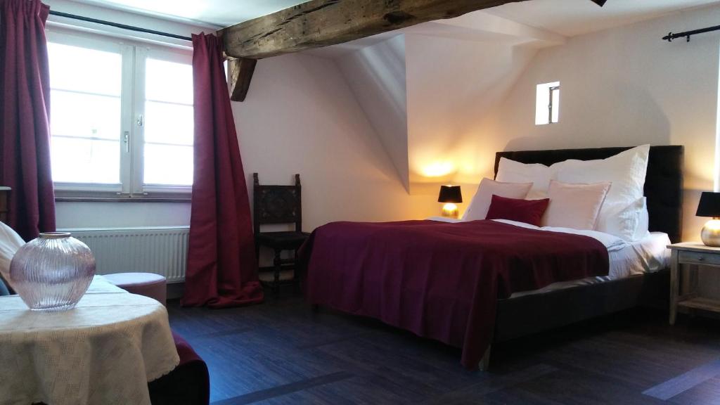 蒙绍Manoir -1654- historisch schlafen in Monschaus Altstadt的一间卧室配有一张红色床罩的床