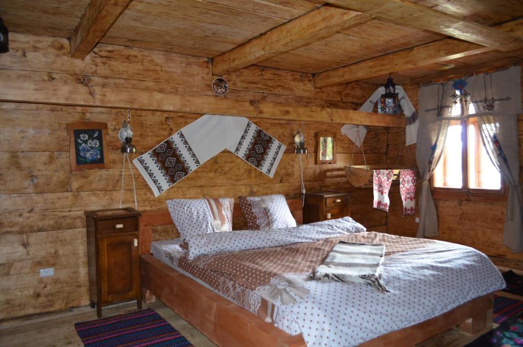 沃罗赫塔Гуцульська Спадщина的卧室配有一张床铺,位于带木墙的房间内
