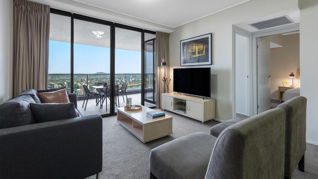 布里斯班Oaks Brisbane Aurora Suites的带沙发和平面电视的客厅