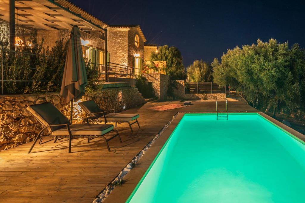 SkináriaYiameli Villas with Private Pool的房屋旁的游泳池配有椅子和遮阳伞