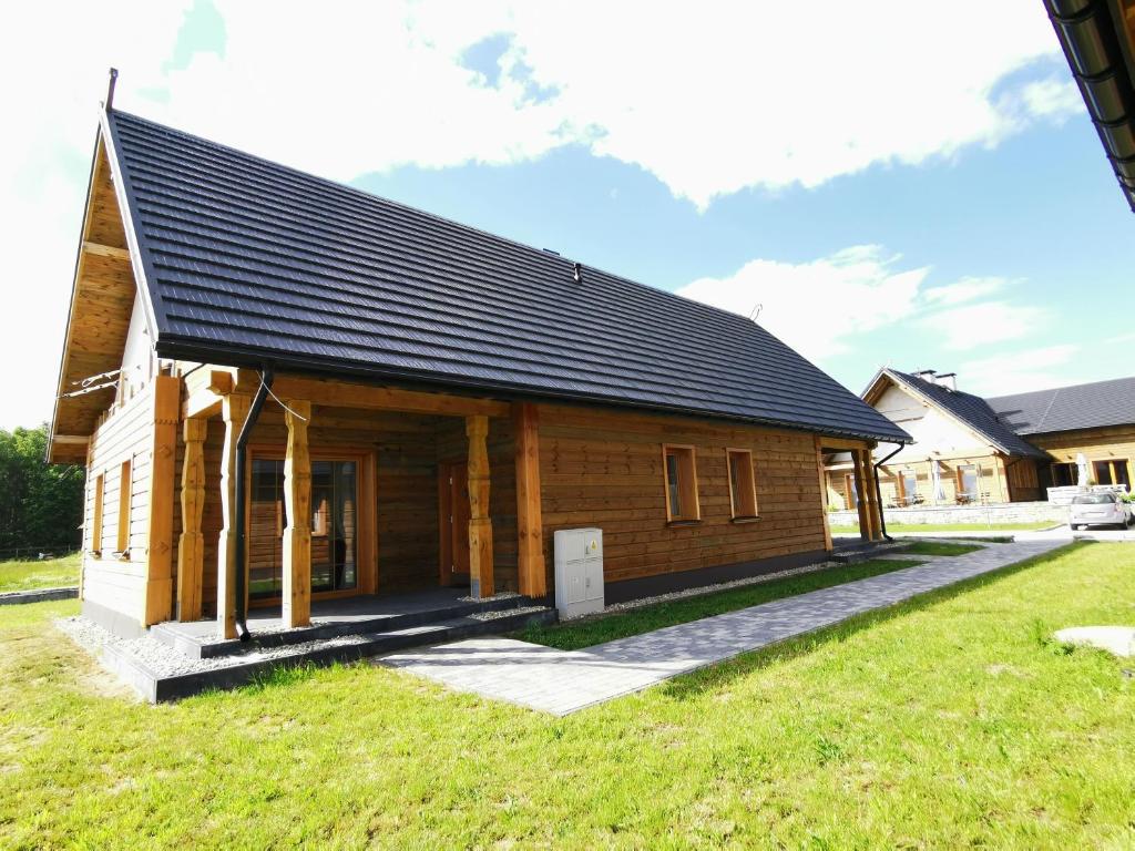 PokrzywnicaApartamenty Stajnia Ojcowizna的黑色屋顶的木屋