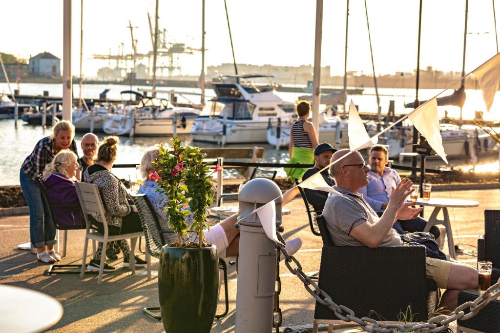 哥德堡船坞酒店的一群人坐在码头的椅子上