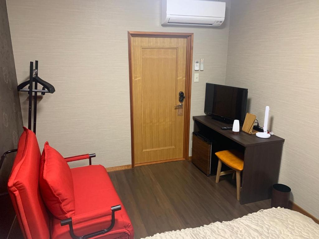 佐渡市Sado - Hotel - Vacation STAY 82496的客房设有书桌、红色椅子和电视。