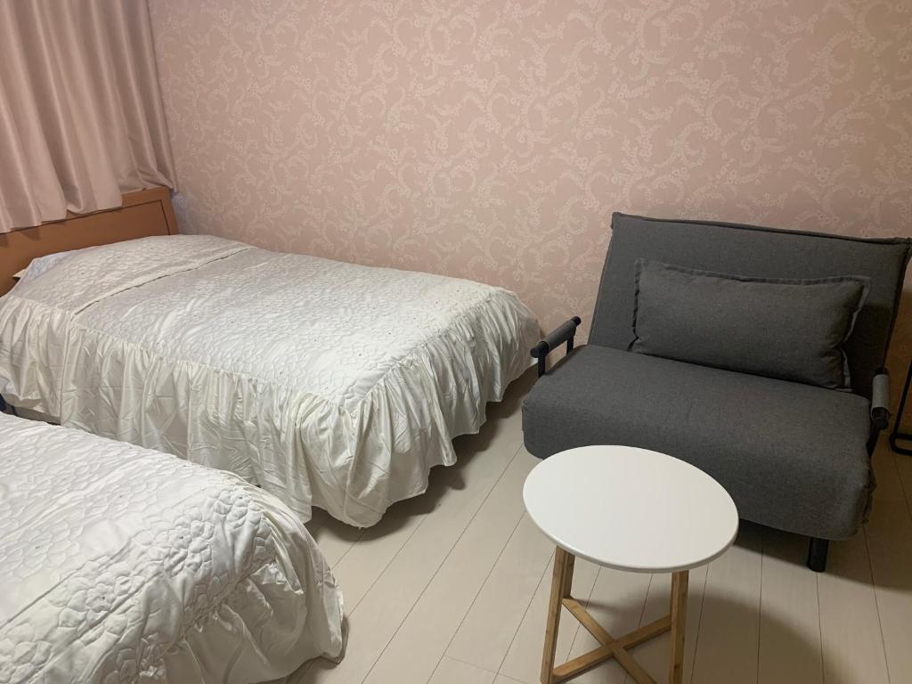 佐渡市Sado - Hotel - Vacation STAY 82476的一间卧室配有一张床、一把椅子和一张桌子
