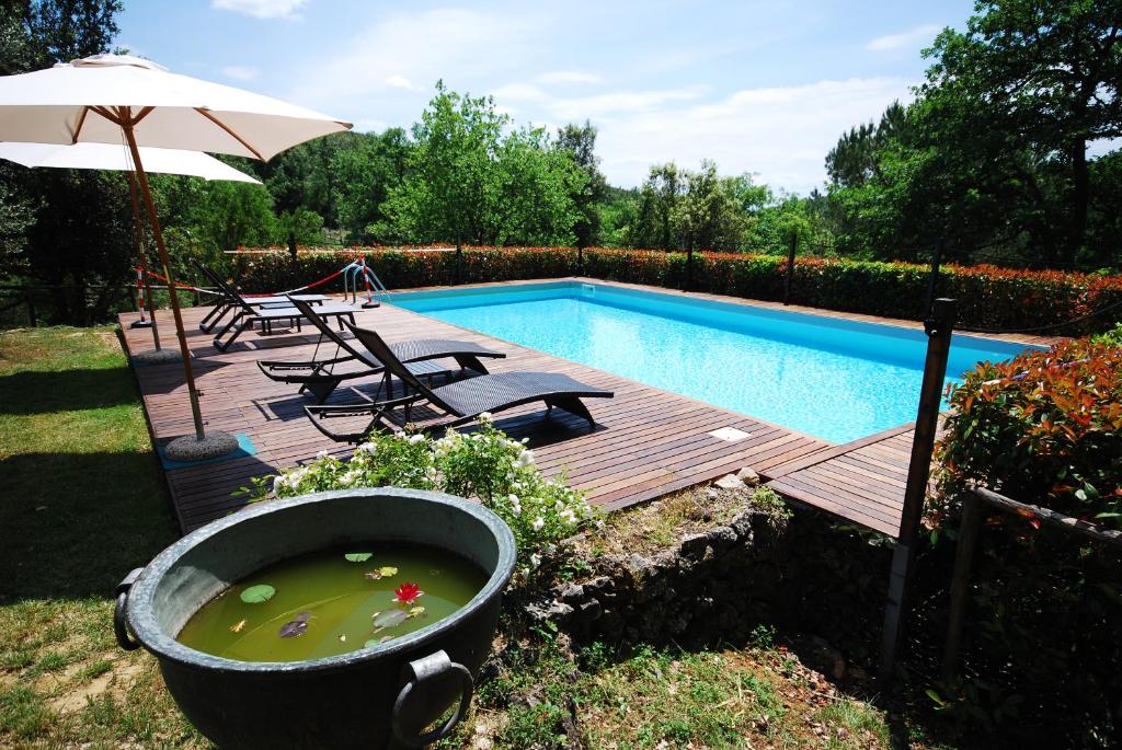 锡耶纳波尔格风笛度假屋的游泳池设有木甲板、浴缸和遮阳伞