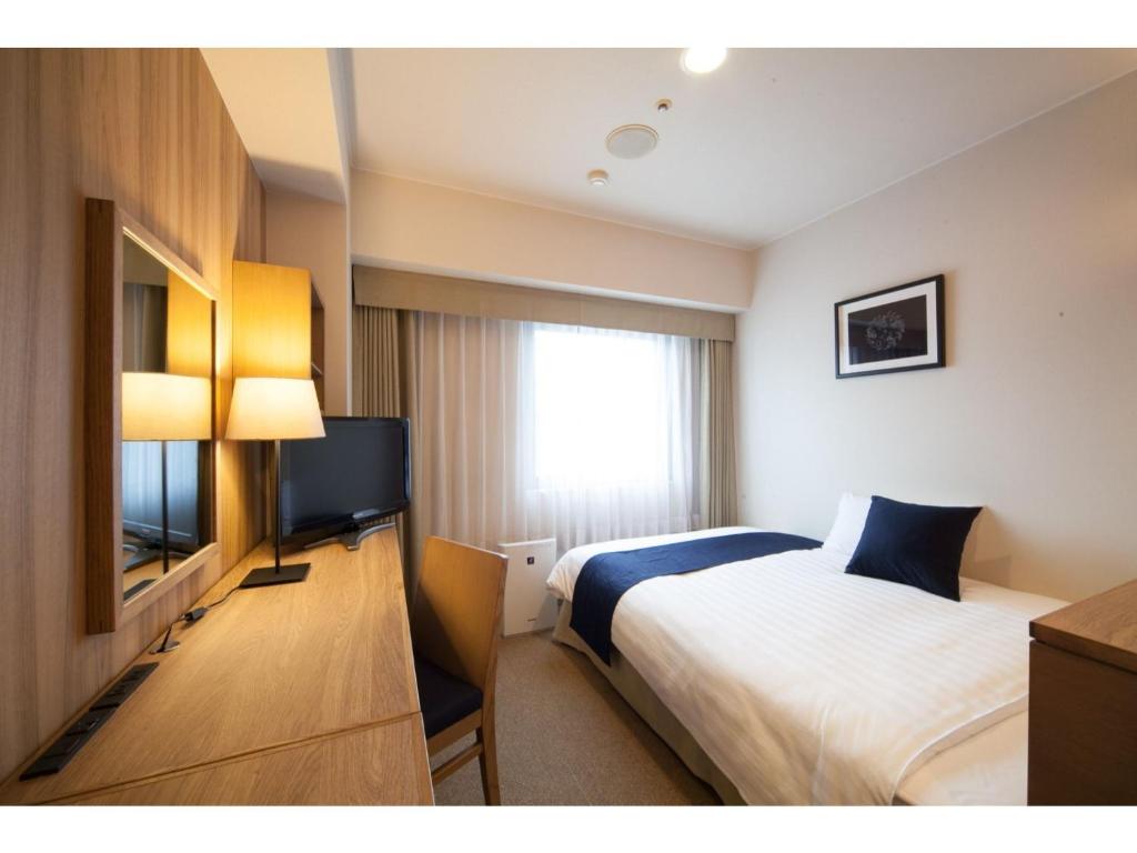 仓吉市Hotel St Palace Kurayoshi - Vacation STAY 82268的配有一张床和一台平面电视的酒店客房