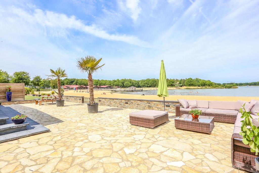 ErmBeach house的一个带沙发和遮阳伞的庭院和一个海滩