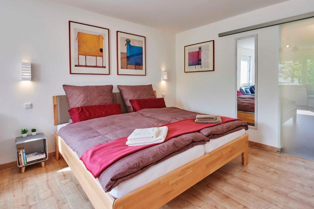 StrullendorfFerien-Apartment Beller的一间卧室配有一张带红色床单的大床