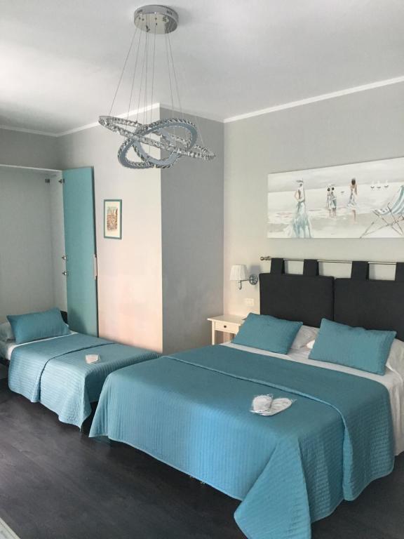 罗马梵蒂冈套房住宿加早餐旅馆的一间卧室配有两张带蓝色床单和吊灯的床。