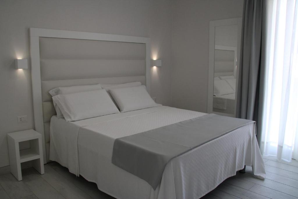 兰佩杜萨La Guitgia Rooms的白色的卧室配有白色的床和镜子