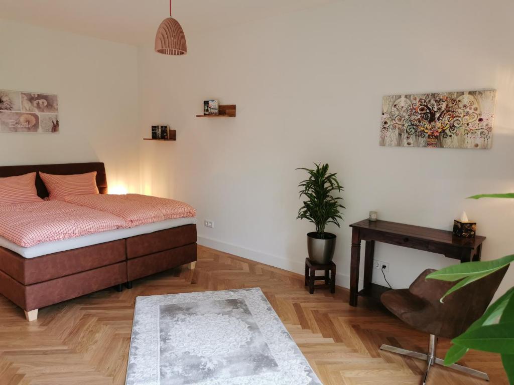 柏林exklusives Studioapartment - in traumhafter Lage direkt am Halensee的一间卧室配有一张床和一张植物桌子