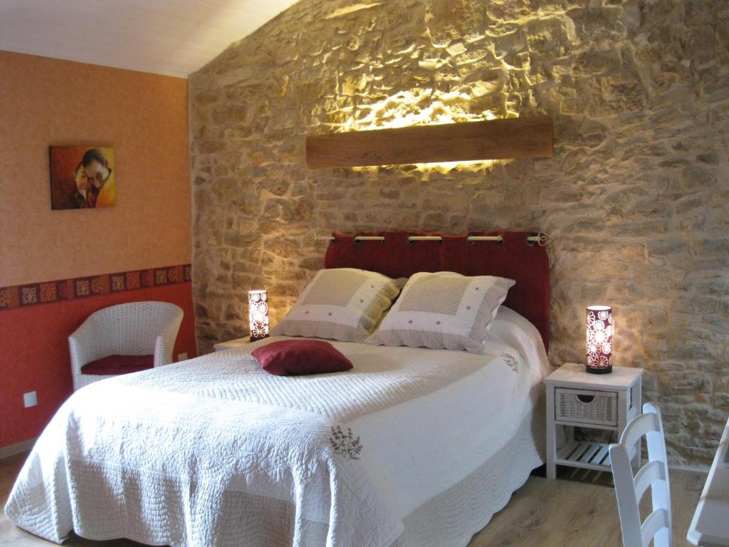 CorveissiatMurmure des buis的卧室配有一张石墙内的大床