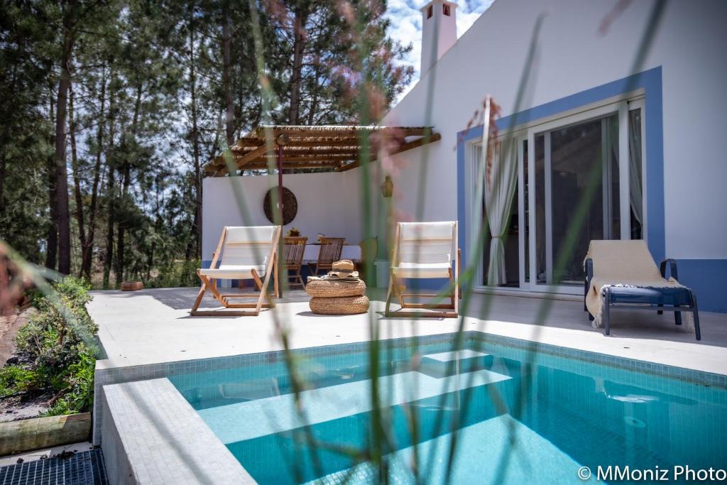 萨尔堡Casas da Horta的一座带游泳池和两把椅子的房子