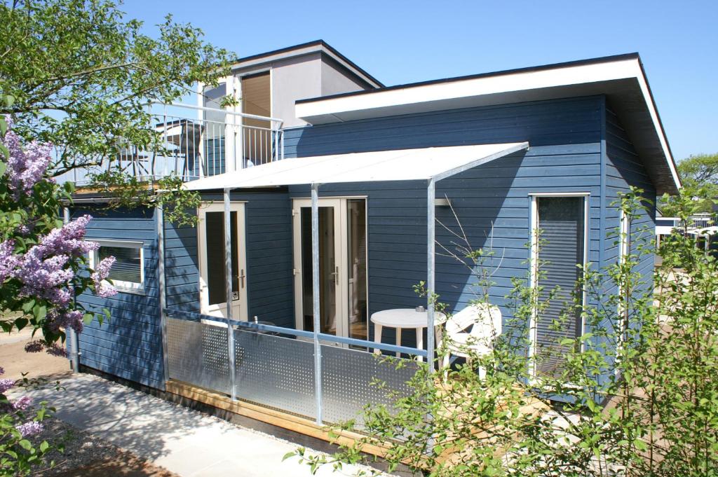 奥本罗Fjordlyst Camping & Cottages的蓝色的房子,四周有围栏