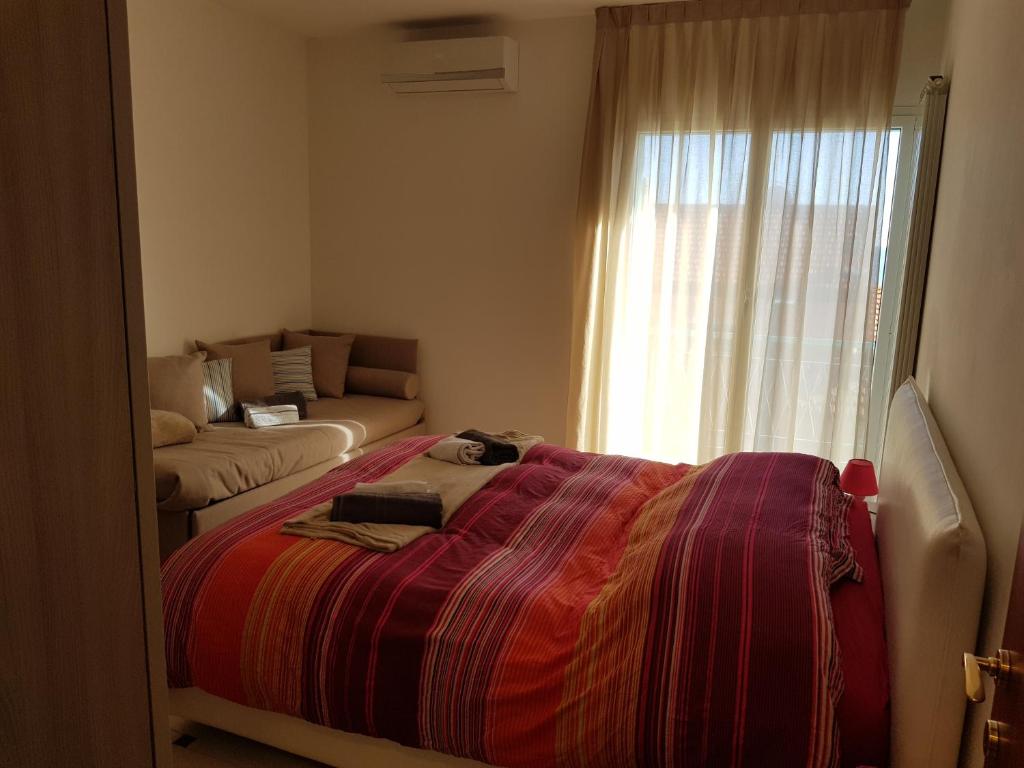 阿尔玛·迪·塔吉亚Case Azzurro的一间卧室配有一张床、一张沙发和一个窗口