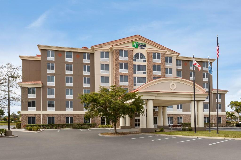 迈尔斯堡Holiday Inn Express Hotel & Suites Fort Myers East - The Forum, an IHG Hotel的一张酒店大楼的图片,里面有一个停车场