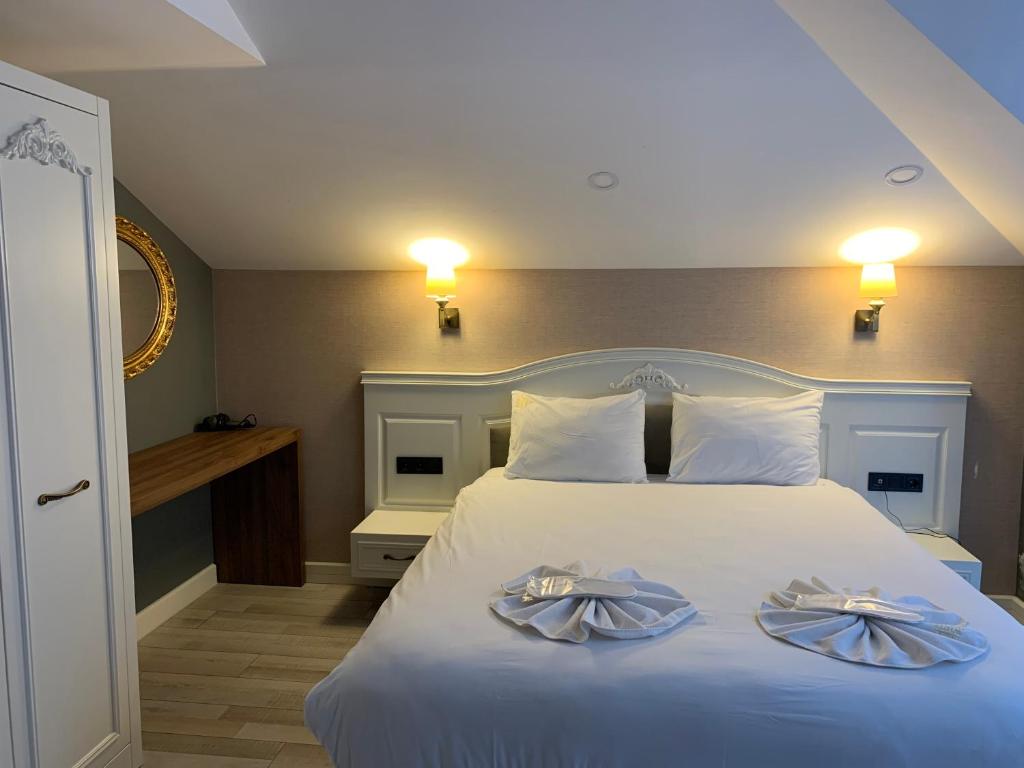 特拉布宗White Golden Suite Hotel的一间卧室配有一张床,上面有两条毛巾