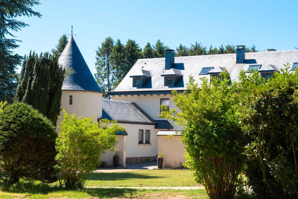 HaletLe Domaine de Wisbeley的蓝色屋顶的大型白色房屋