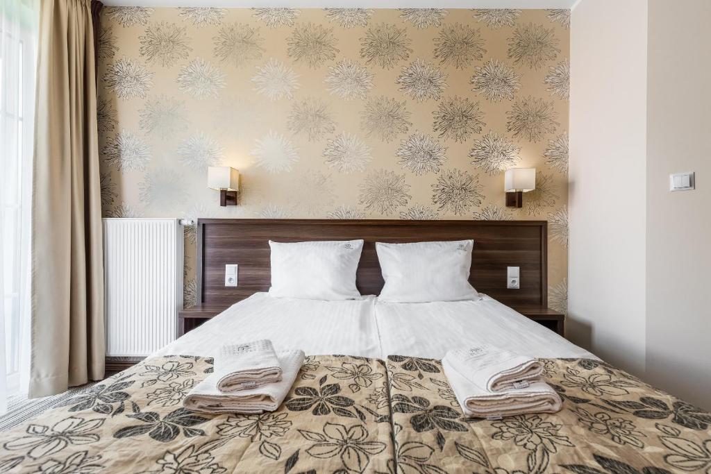 德兹维济诺帕里斯基旅馆的一间卧室配有一张床,上面有两条毛巾
