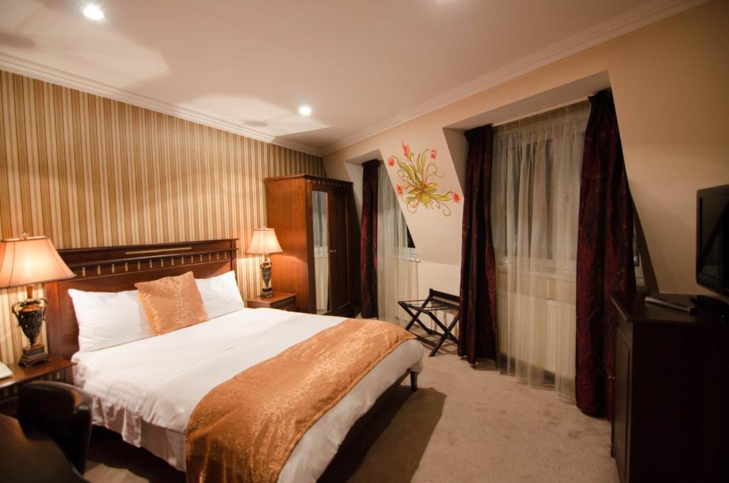 布加勒斯特摩纳哥精品酒店的酒店客房,配有床和电视