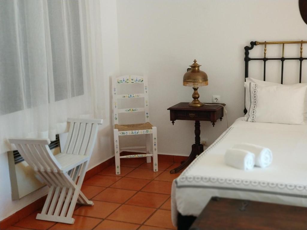 米尔芳提斯城Casa das Hortências By Alojamentos Vitinho - Vila Nova MIlfontes的一间卧室配有一张床、一把椅子和一张桌子