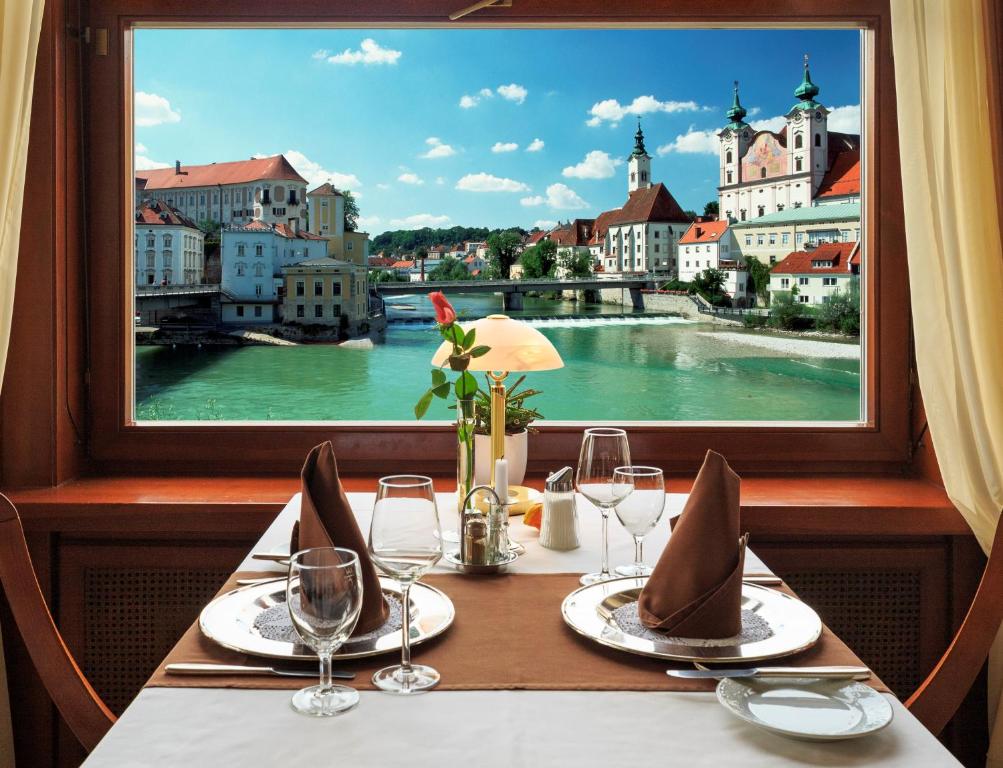 施泰尔民切玛酒店及餐厅的一张桌子,从窗口可欣赏到河流美景