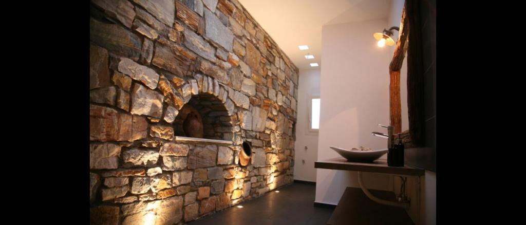 纳克索乔拉Chez Kiki et Ioannis的走廊上的石墙,带水槽