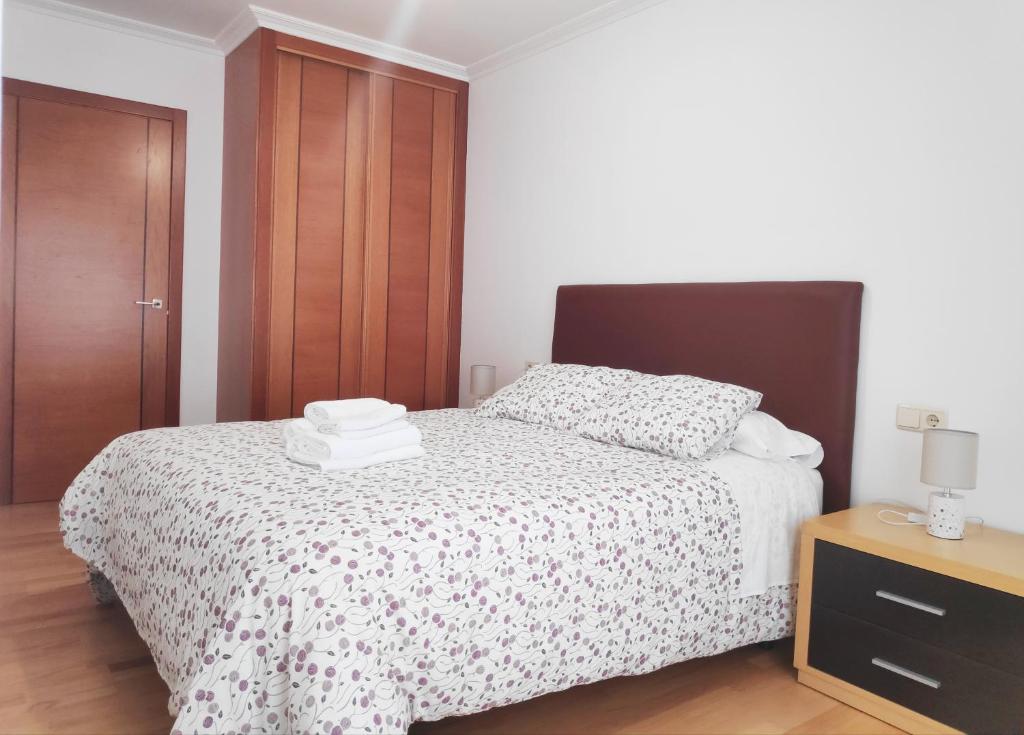 马林Apartamento Naval的一间卧室配有一张床和一个木制橱柜