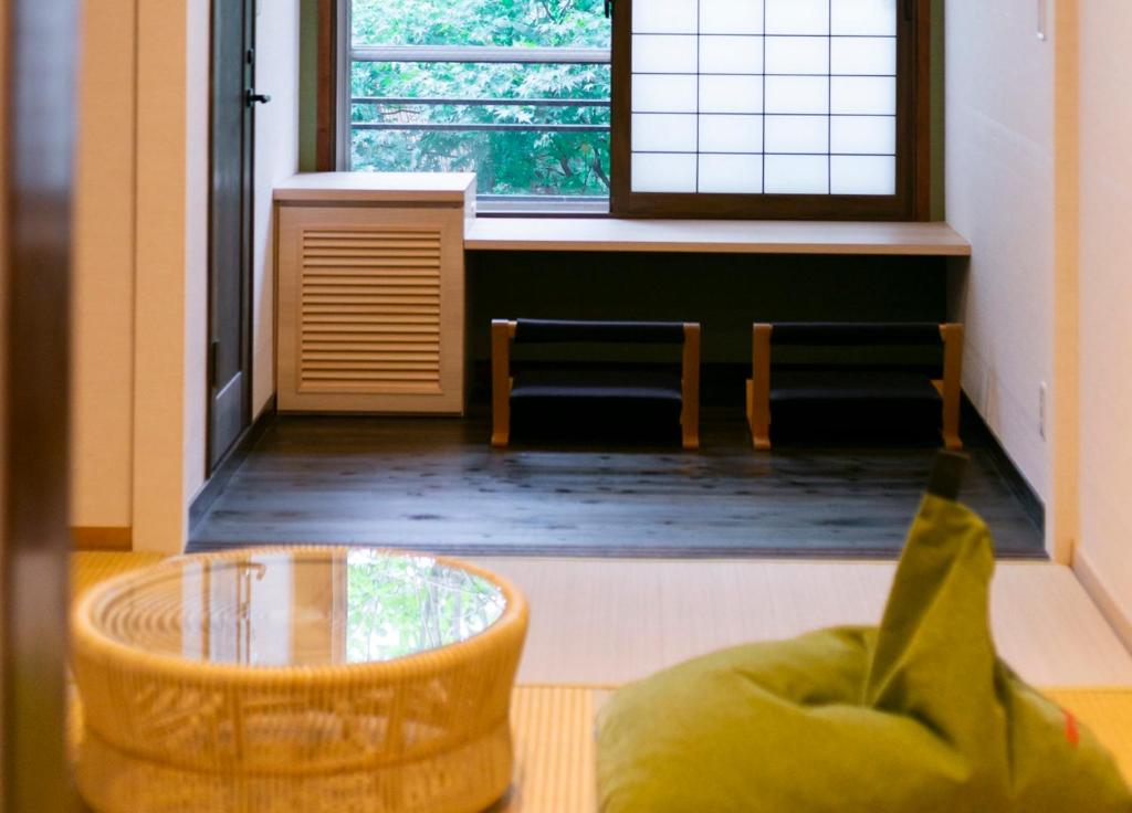 嬉野市吉田日式旅馆的客房设有桌椅和窗户。