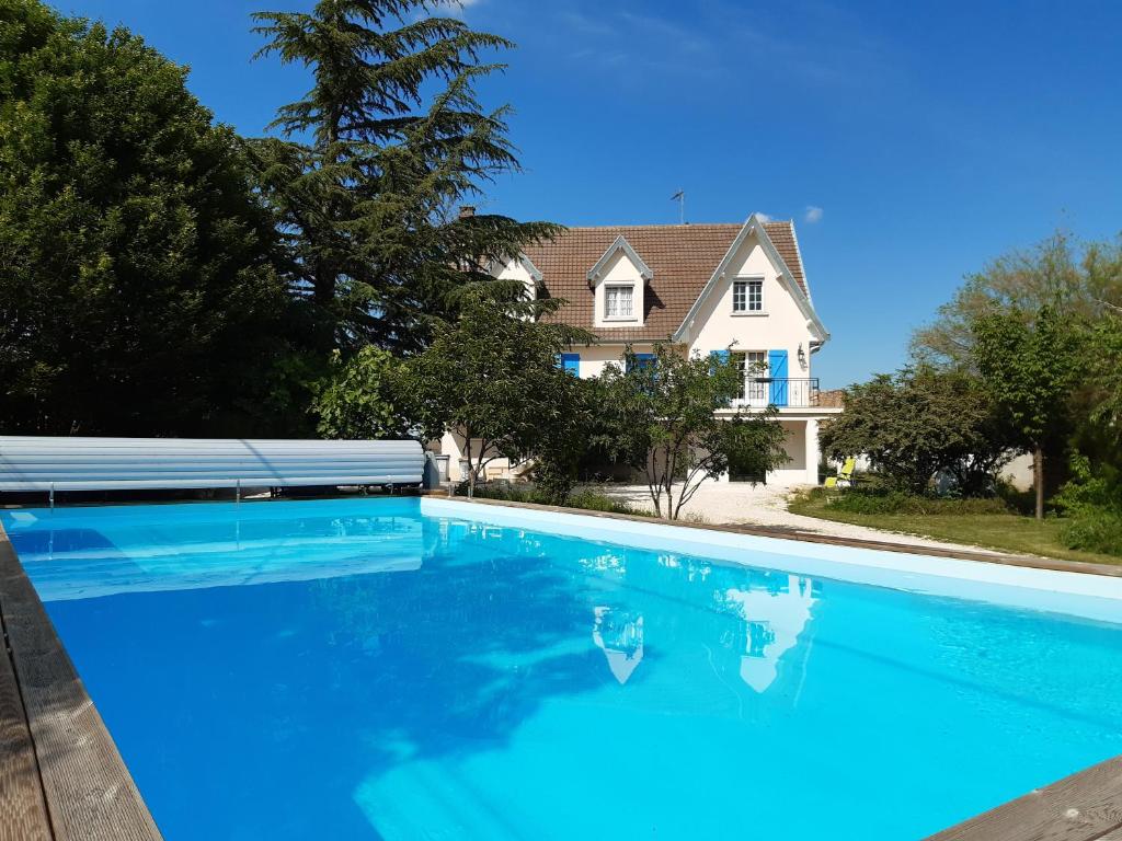 CorpeauLa maison bleue的一座大蓝色游泳池,位于房子前