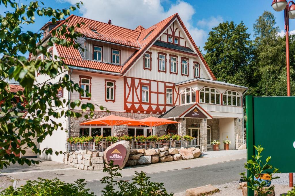 施尔奇Hotel Villa Bodeblick的前面有橘子伞的大房子