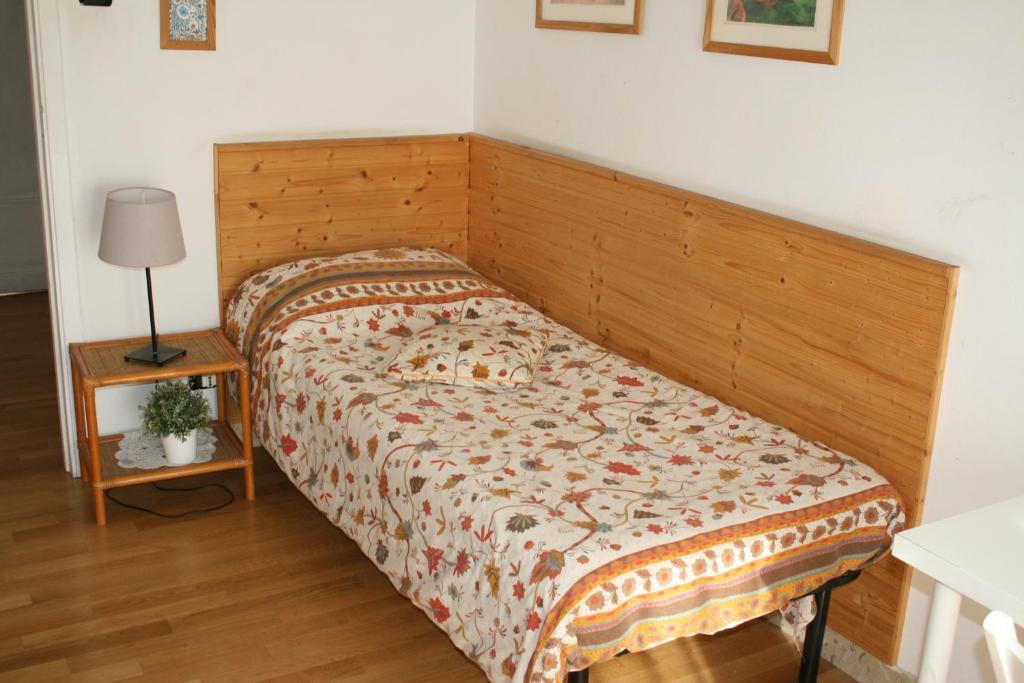卡塔尼亚卡萨尼皮特拉酒店的卧室内的一张带木制床头板的床