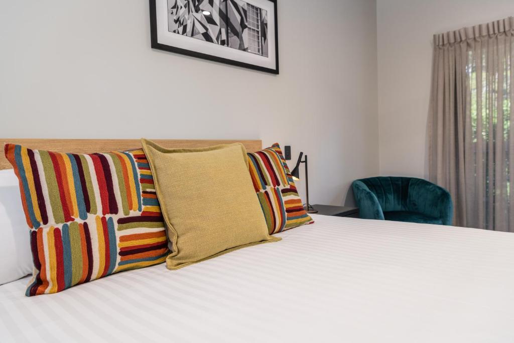 土乌巴AVENUE MOTEL APARTMENTS的一间卧室配有带色彩缤纷枕头的床。