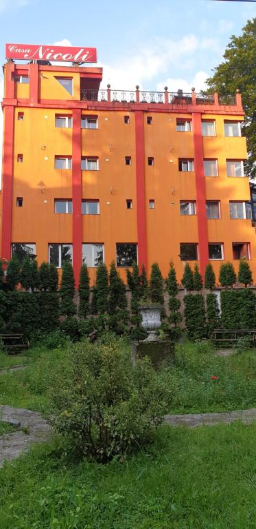 百乐·奥拉内斯蒂Casa Nicoli的一座大型的橙色建筑,前面有树木