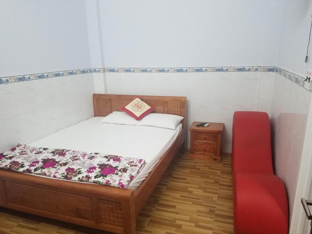 岘港MyDungmotel的一间卧室配有一张床和一张红色椅子