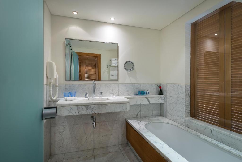 埃拉特Royal Beach Eilat by Isrotel Exclusive的带浴缸和水槽的浴室
