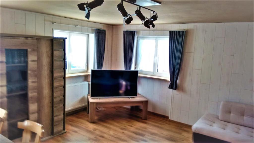 博尔斯特尔朗Ferienwohnung Schaule的客厅配有桌子和2扇窗户,电视