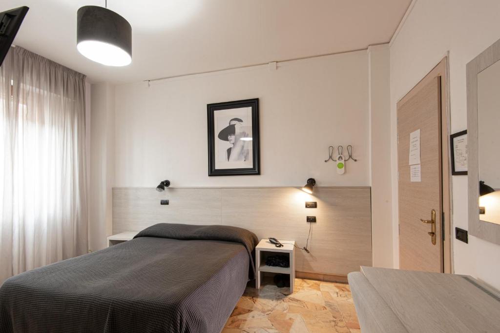 佛罗伦萨卡勒吉酒店的一间卧室设有一张大床和一个窗户。