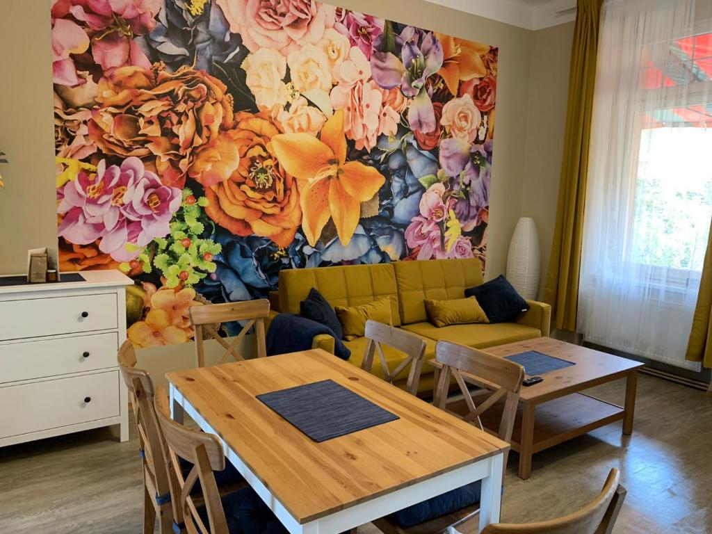 德辛Apartmán Galerie的客厅配有桌子和花墙