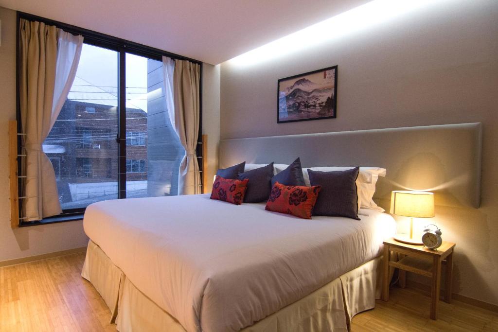 白马村小春套房度假酒店的一间卧室设有一张大床和大窗户