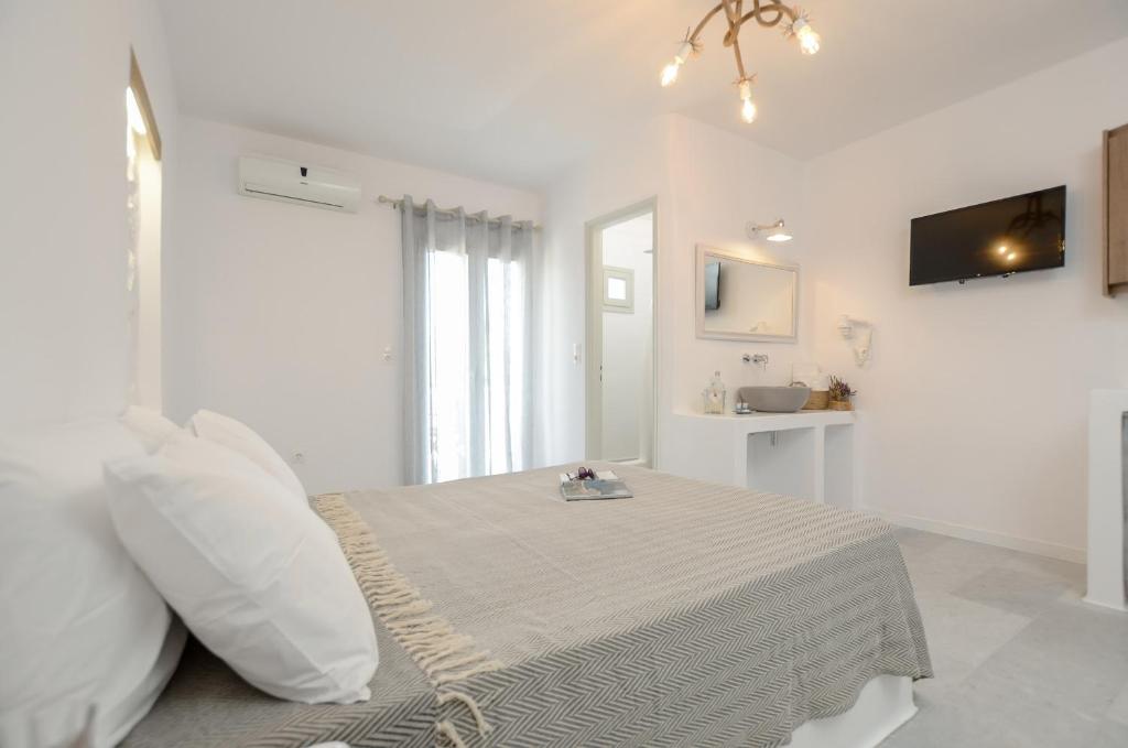 纳克索乔拉Casa Verde Di Naxos的白色的客房配有床和电视。