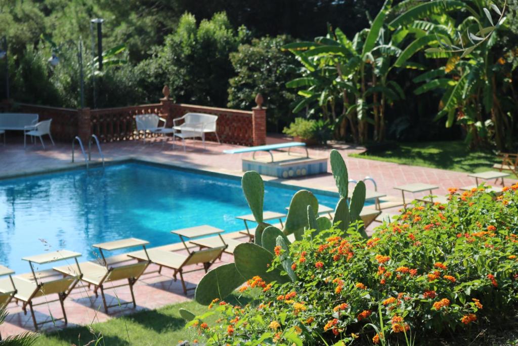 阿茨特雷扎德尔帕尔梅别墅酒店的游泳池配有桌椅和桌椅